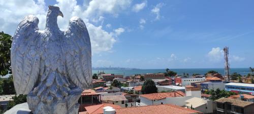 a statue of two birds standing on top of a city at Pousada Jardins - Mar Grande in Vera Cruz de Itaparica