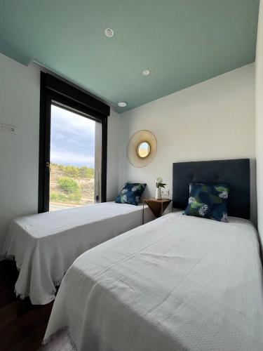 two beds in a room with a window at Sea Hills semidetached Luxury Villa in Finestrat