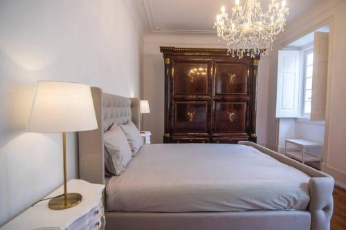 1 dormitorio con 1 cama con lámpara y lámpara de araña en Bendi Guest House Blue Experience, en Sintra