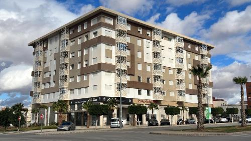 a large building with cars parked in front of it at Haut Standing Appartement - Centre Ville Oujda in Oujda