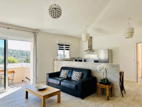 a living room with a black couch and a table at Residence Casa Di Paoli in Porto-Vecchio