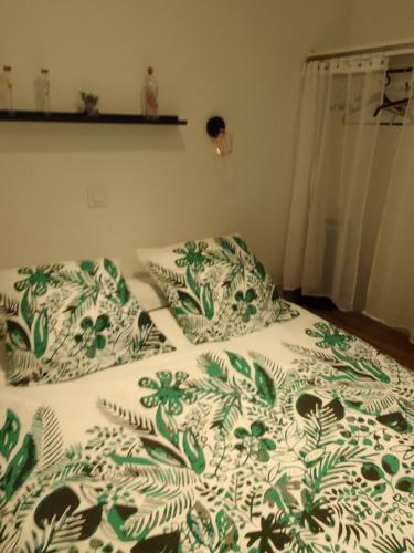- un lit avec une couverture et des oreillers verts et blancs dans l'établissement chez LOLO, à Saint-Nazaire