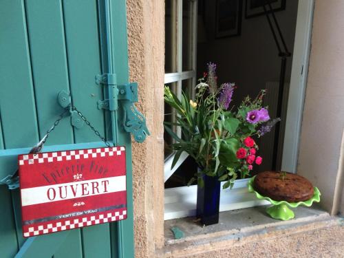 une pancarte sur une fenêtre avec un vase de fleurs dans l'établissement La Closerie de l'Autan, à Fenouillet