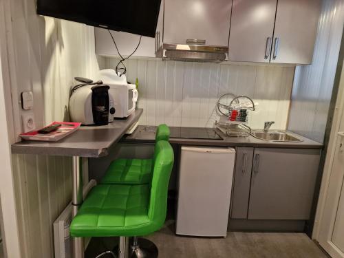 a kitchen with a green stool in a small kitchen at LES CERISIERS 1 in Nogaro