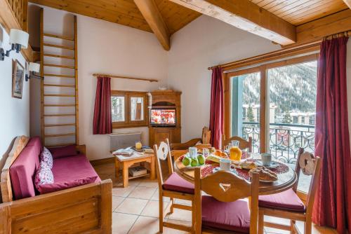 a living room with a table and a dining room at Lagrange Vacances Le Cristal d'Argentière in Chamonix-Mont-Blanc