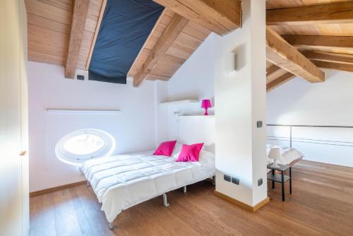 a bedroom with a bed with pink pillows at La finestra sulle Langhe - m3langhe in Cherasco