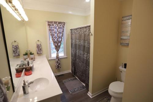 y baño con aseo, lavabo y ducha. en Golf community/Beautiful house with a golf view, en Warner Robins