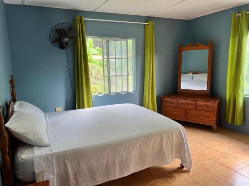 a bedroom with a bed and a mirror and a window at Tha Lagoon Spot in Port Antonio