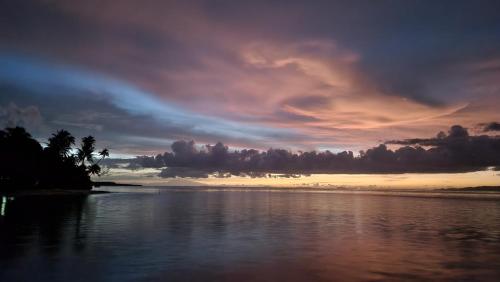 a sunset over a body of water with clouds at Terimakasih homestay in Pulau Mansuar