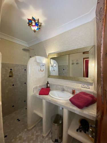 y baño con lavabo y espejo. en Riad Tafilag en Taroudant