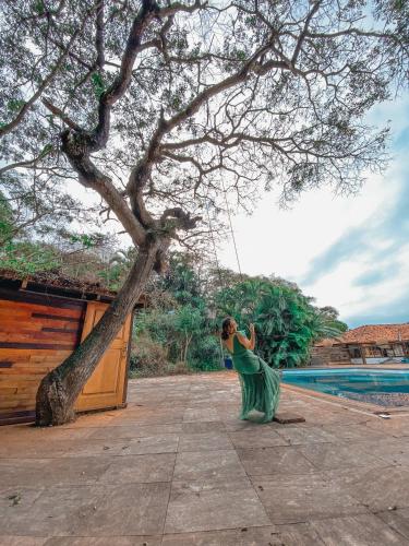 a woman in a green dress hanging from a tree at The Eco Palace Hostel in Búzios