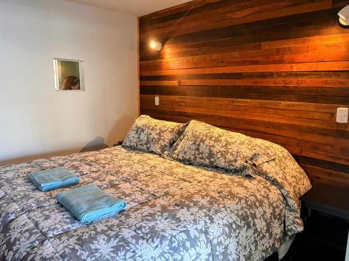 - une chambre avec un lit et un mur en bois dans l'établissement Departamento en Reñaca Vista al Mar, à Viña del Mar