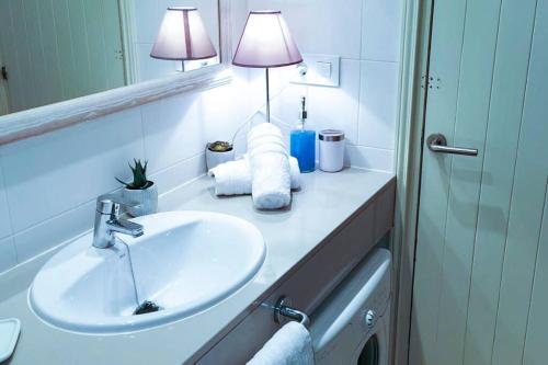 bagno con lavandino bianco e specchio di Bord de mer & Piscine à Son Bou - Alaior / 4 pers ad Alaior