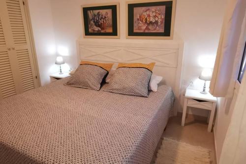 a bedroom with a bed with two tables and two lamps at Bord de mer & Piscine à Son Bou - Alaior / 4 pers in Alaior