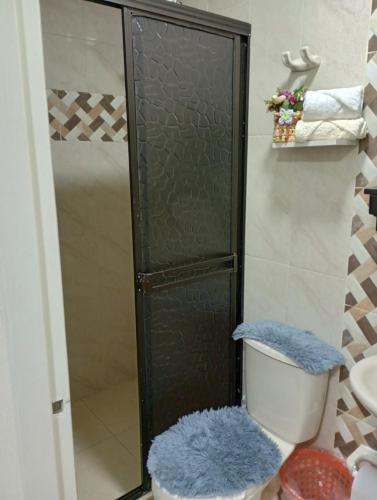 a bathroom with a shower with a toilet with a blue rug at Araucarias Inn 2 in Santa Rosa de Cabal