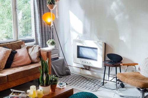 sala de estar con sofá y TV en Cocomama en Ámsterdam