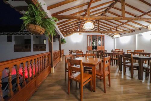 a dining room with wooden tables and chairs at Hotel las Palmas in Villa de Leyva
