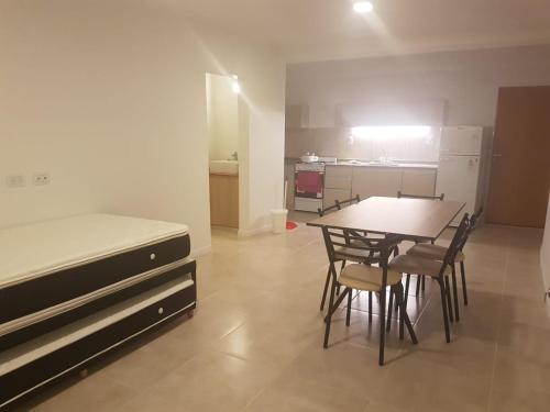 1 dormitorio con 1 cama, mesa y sillas en Departamento en Costanera en Gualeguaychú