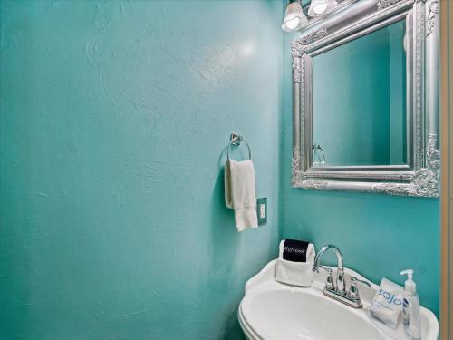 a blue bathroom with a sink and a mirror at Bishops Beach in Galveston