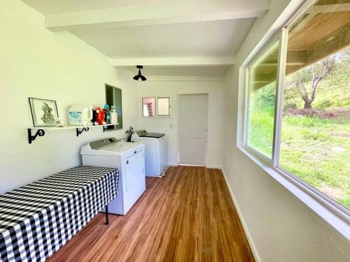 uma pequena cozinha com um lavatório e uma janela em Fotis House em Naalehu