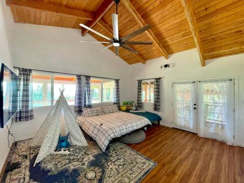 um quarto com uma cama e uma ventoinha de tecto em Fotis House em Naalehu