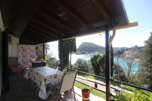 uma varanda com uma mesa e vista para a água em Niky's cottage em Paleokastritsa