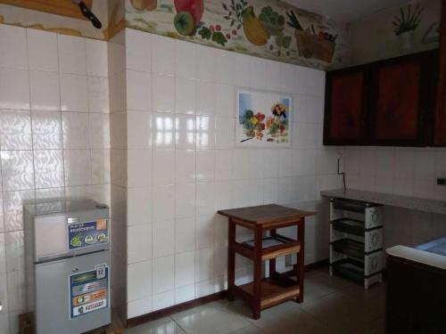 eine Küche mit einem kleinen Tisch und einem Kühlschrank in der Unterkunft Hôtel Résidence Georges Colette in Yopougon