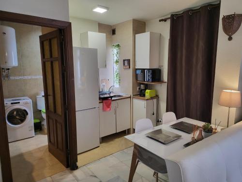 małą kuchnię ze stołem i białą lodówką w obiekcie Beach Apartments Old Town II w mieście Estepona