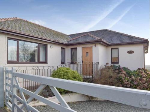 a white house with a fence in front of it at Meadow View in Haverfordwest