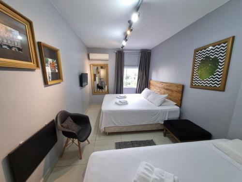 una camera d'albergo con due letti e una sedia di Condomínio Siqueira Campos a San Paolo