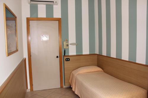 a small bedroom with a bed and a door at Hotel Milano in Como