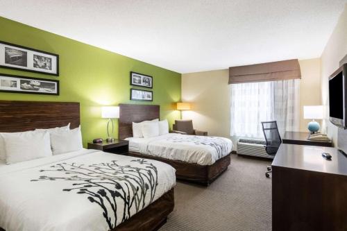 a hotel room with two beds and a television at Sleep Inn in Fredericksburg