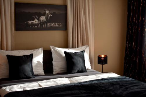 a bedroom with a bed with black and white pillows at ROOMS FOR ADULTS ONLY - Hotel Jägerhof Wörthersee in Krumpendorf am Wörthersee