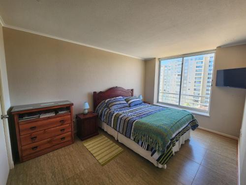 1 dormitorio con 1 cama, vestidor y ventana en Departamento Laguna Vista, en Algarrobo