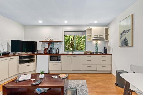 a kitchen with white cabinets and a wooden table at Hunchy Hideaway in Montville