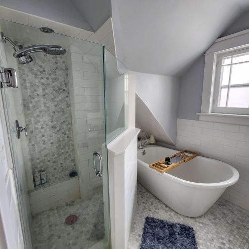 uma casa de banho com um chuveiro e uma banheira. em The Pandora Century Home em Kitchener