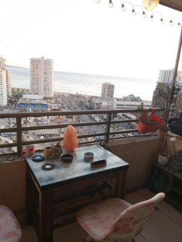 a table on a balcony with a view of the beach at Habitación frente al mar in Iquique