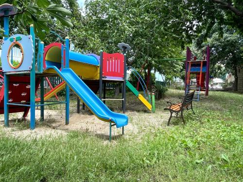 un parque infantil con un tobogán en el césped en AMADINA GARDEN - Bed & Breakfast or Half Board en Lozenets