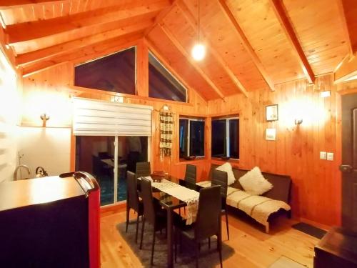 a living room with a table and a couch at Cabañas Bosquemar 1 in Queilén