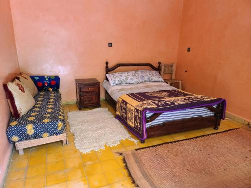 a bedroom with a bed and a table and a couch at Dar de l'Atlas in Lalla Takerkoust