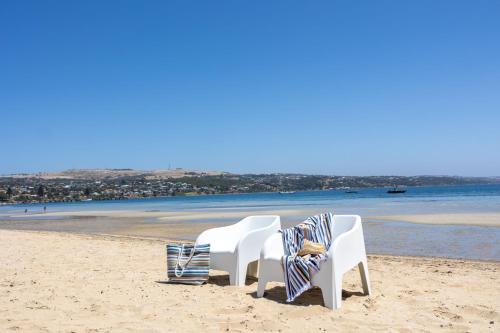 a couple of chairs sitting on a beach at Port Lincoln Beachfront Apartment 7 in Port Lincoln