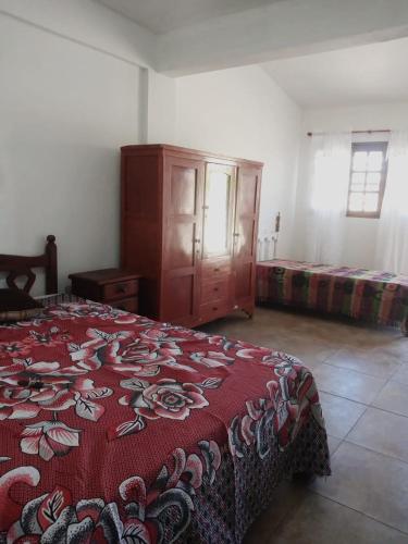 1 dormitorio con 1 cama y vestidor con manta roja en Martinez en Salta