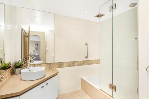 a white bathroom with a sink and a shower at Cashelmara Burleigh - Hosted by Burleigh Letting in Gold Coast