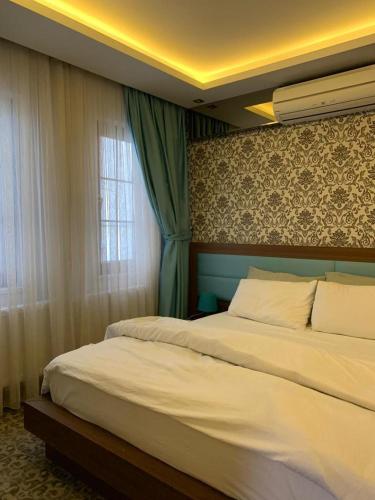 Un dormitorio con una cama grande y una ventana en Royal Butik House, en Bursa