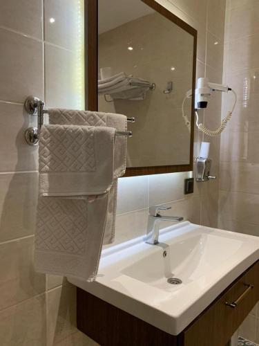 y baño con lavabo, espejo y toallas. en Royal Butik House, en Bursa