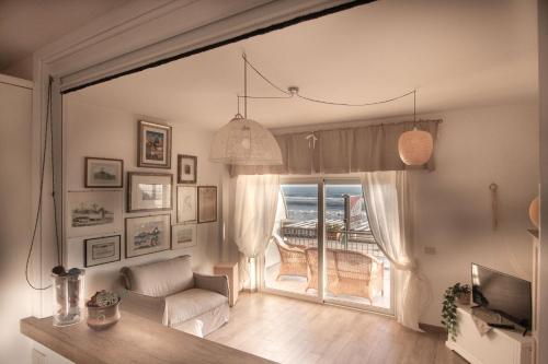 sala de estar con sofá y ventana en TERRACINA SEA FRONT FANTASTIC APARTMENT WITH ONE CAR PRIVATE OPEN PARKING en Terracina