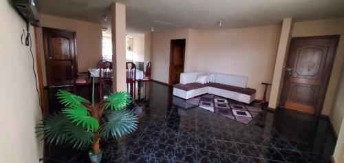 sala de estar con cama y planta en Departamento en Cuenca, 3 Habitaciones y parqueo gratis, en Cuenca