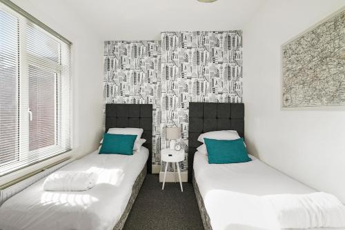 sypialnia z 2 łóżkami i malowidłem ściennym w obiekcie Group Stays Birmingham w Birmingham