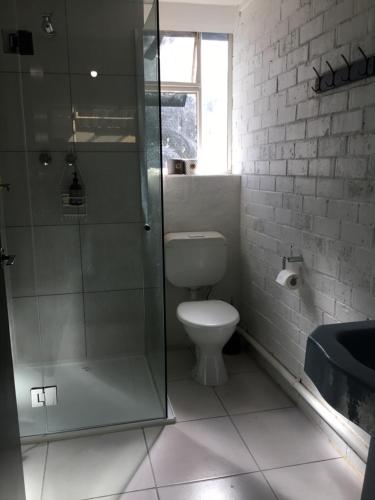 a bathroom with a toilet and a glass shower at The Old Butter Factory at Springhurst Estate in Springhurst