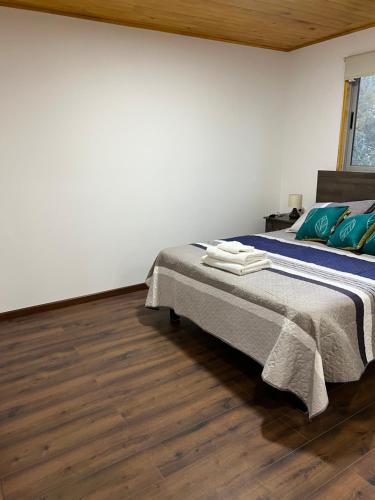 a bedroom with a bed and a wooden floor at Hostería Estelita in Panimávida